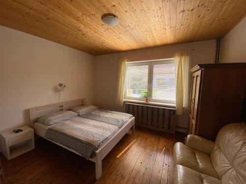 a bedroom with a bed and a window and a couch at Ubytování u Malinkovičů in Břeclav