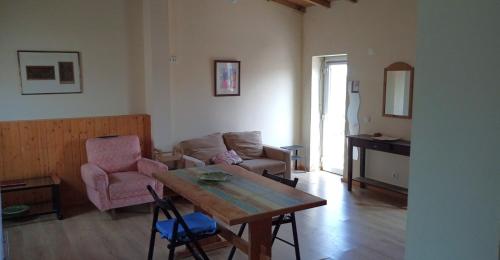 a living room with a table and a couch at Casa do Meio in Nadadouro