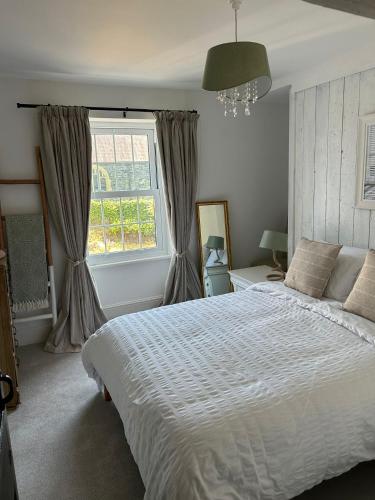 a bedroom with a white bed and a window at 8 Willow Street in Llanrwst