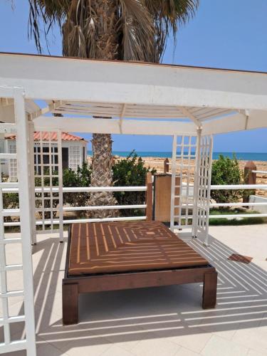 a swing bed on a porch with a palm tree at Vivenda Mia in Beirona