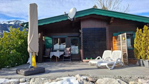 a house with a table and chairs and an umbrella at Chalet Panorama Tirol in Hofen