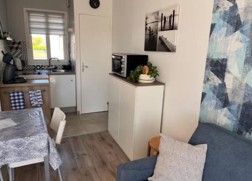 une petite cuisine avec une table et un micro-ondes dans l'établissement Studio avec grand balcon Marin, à Berck-sur-Mer