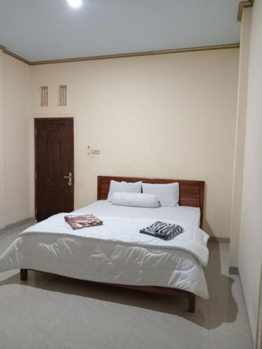 a bedroom with a bed with two towels on it at PENDIK Home Stay in Labuan Bajo