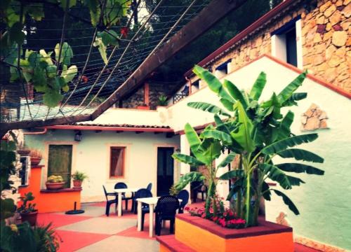 a courtyard of a house with a table and chairs at Sa Funtana in Gonnesa