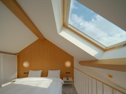 a bedroom with a bed and a large window at Bellhop Tbilisi in Tbilisi City