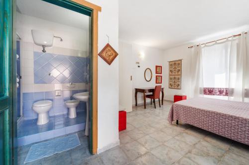 a bedroom with a bed and a bathroom at Sa Funtana in Gonnesa