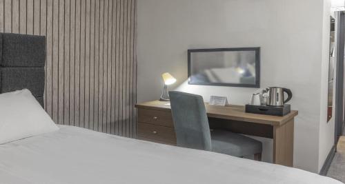 a bedroom with a desk with a bed and a chair at Hotel St Pierre, Sure Hotel Collection by Best Western in Wakefield