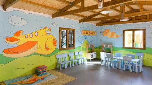 a room with a classroom with chairs and a wall with a airplane mural at Servatur Waikiki in Playa del Ingles
