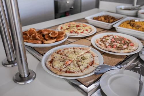 a table with plates of pizzas and other food at Servatur Waikiki in Playa del Ingles
