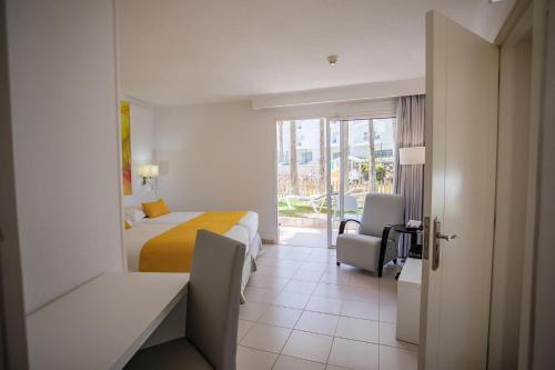 a hotel room with a bed and a chair at Servatur Waikiki in Playa del Ingles