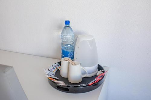 a container with a bottle of water and cups at Servatur Waikiki in Playa del Ingles