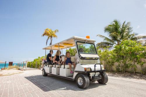 a golf cart with people riding on the road at Ports of Call Resort in Grace Bay