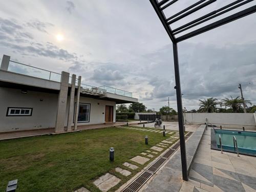 a house with a yard with a pool table at Bluewater Farms 2BR Villa with pool by Homeyhuts in Hyderabad
