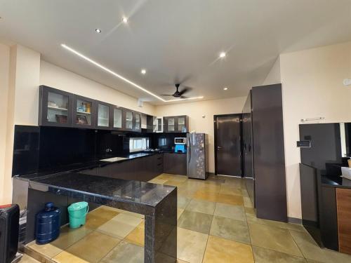a large kitchen with a black counter top at Bluewater Farms 2BR Villa with pool by Homeyhuts in Hyderabad
