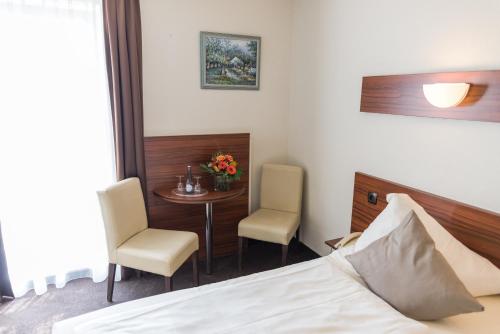 a hotel room with a bed and a table and chairs at Hotel am Wall in Soest