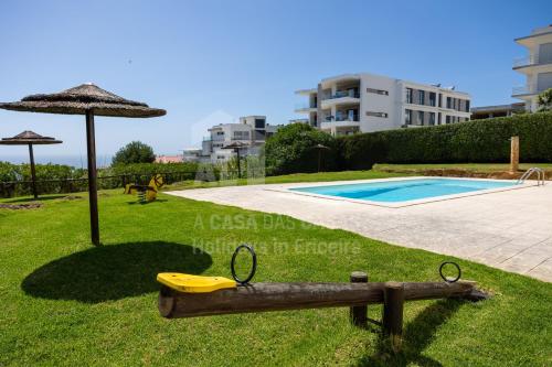 an image of a swimming pool and an umbrella at Blue Beach by ACasaDasCasas in Ericeira
