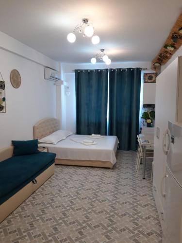a bedroom with a bed and a blue curtain at Seatime Studio in primul rând la mare in Mamaia Sat/Năvodari