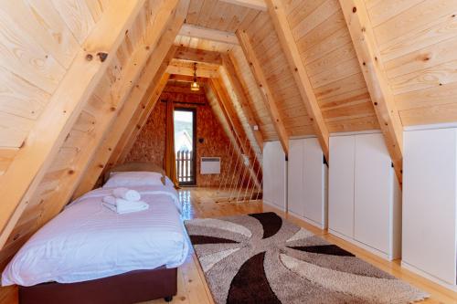 a bedroom in a log cabin with a bed at WIND Cottage in Žabljak