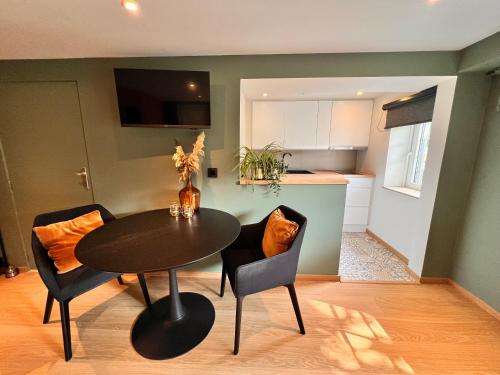 a dining room with a table and chairs and a kitchen at Studio with sauna in Meise