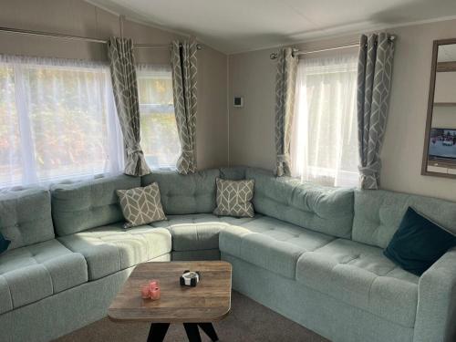 a living room with a couch and a coffee table at Wiseman Bridge Caravan Retreat- Minutes to Beach in Narberth
