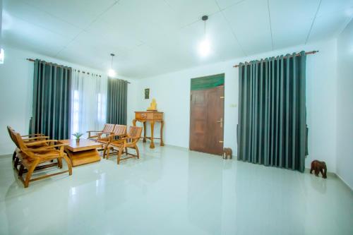 a living room with wooden chairs and a table at Villa Enchanté - Apartment in Nugegoda 2BR in Talapatpitiya