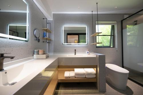 un bagno con vasca, WC e lavandino di Jiuzhaigou Jijian Nanshan B&B a Valle del Jiuzhaigou