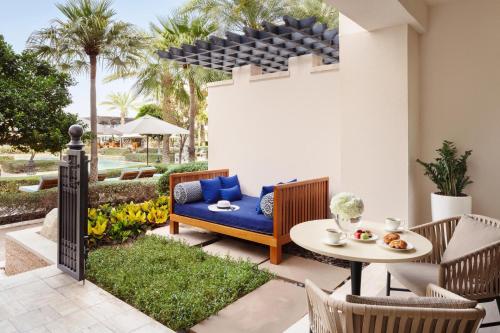 a patio with a blue couch and a table and chairs at Jumeirah Al Naseem Dubai in Dubai