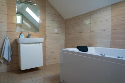 a bathroom with a tub and a sink and a mirror at Sunset Villa Apartments in Ohrid