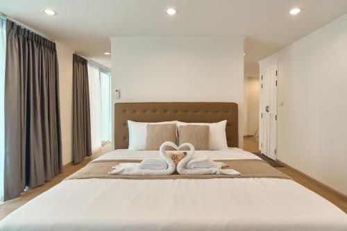 a bedroom with two swans towels on a bed at Luxury Pool Villa in the Heart of the Chiang Mai in Chiang Mai