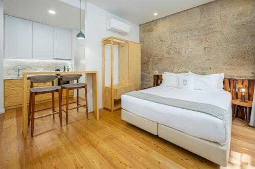 a hotel room with a bed and a kitchen at Porta Nobre Boutique Hotel by Aspasios in Porto