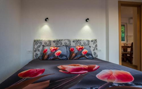 a bedroom with a bed with pink flowers on it at Sunset Villa Apartments in Ohrid