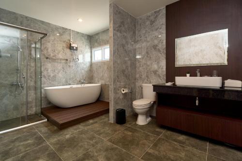 a bathroom with a tub and a sink and a toilet at Luxury Pool Villa in the Heart of the Chiang Mai in Chiang Mai