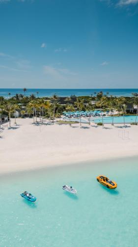 three boats in the water next to a beach at Joy Island Maldives All Inclusive Resort in Male City