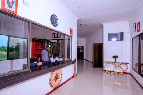 a restaurant with two people sitting at a counter at Luxe Countryside Convention Center in Livingstone