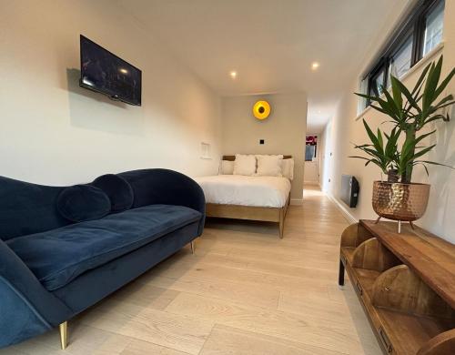 a living room with a couch and a bed at Cosy Home with beautiful views in Bisley