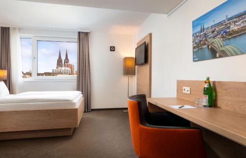 una habitación de hotel con una cama y un escritorio en Stadthotel am Römerturm, en Colonia