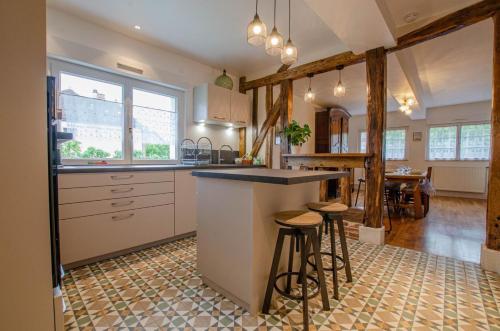 a kitchen with a counter and stools in it at Le four de mimile in Montieramey