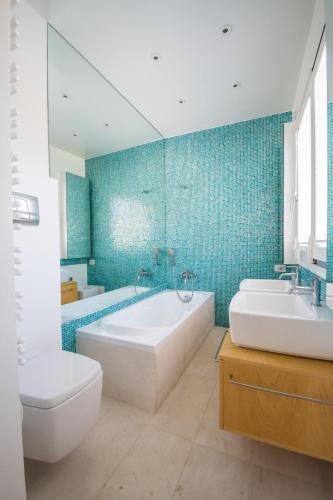 a bathroom with two sinks and a tub and a toilet at Villa Ginevra- Private Pool in Orosei