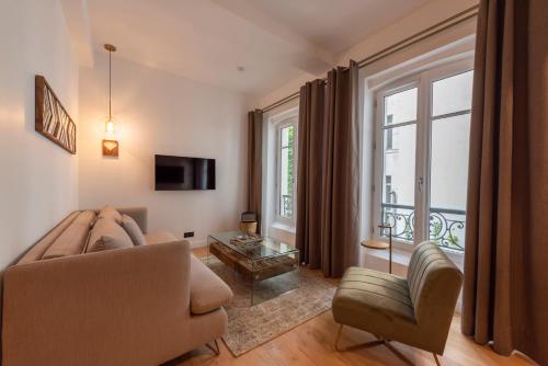 ein Wohnzimmer mit einer Couch und einem Fenster in der Unterkunft O'Lord, 4 Etoiles, Residence de Luxe Champs-Elysees in Paris