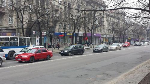 a busy city street with cars and a bus at Central Park Apartments in Chişinău