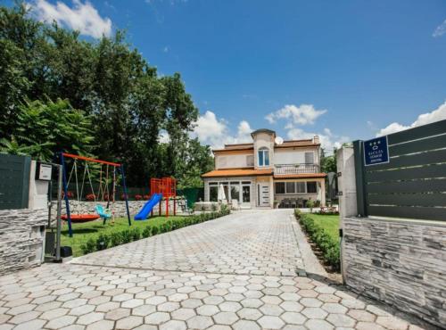 a house with a playground in front of it at Countryside Villa Tajo in Imotski