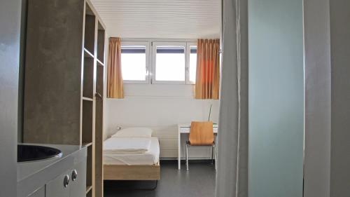 a small room with a bed and a desk at Ostello Montebello - Bellinzona Youth Hostel in Bellinzona