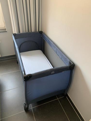 a small blue bed in a corner of a room at Vakantieappartement Emiel Centrum Oostende met garage in Ostend