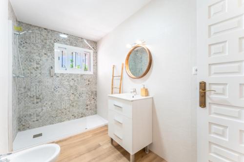 Un baño blanco con ducha y lavabo. en VB Villa Coto 7BR w Pool & Views, en Santa Fe de los Boliches