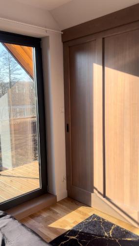 a room with a large window and a door at Domek w Jesionach in Sława