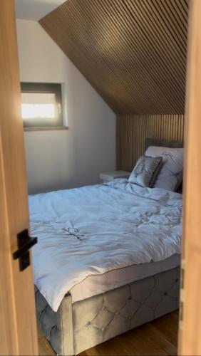 a bedroom with a bed with a wooden headboard at Domek w Jesionach in Sława
