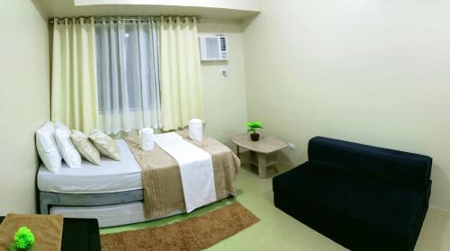 a bedroom with a bed and a chair in it at The Suite Pod I CDO CondoStaycation in Cagayan de Oro