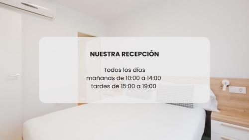 a white bed with a sign on top of it at Pio XII Apartments Valencia in Valencia