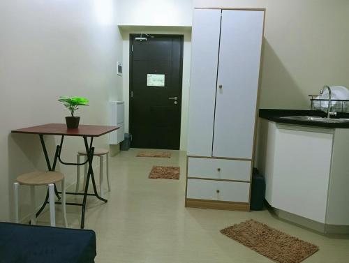 a small kitchen with a table and a black door at The Suite Pod I CDO CondoStaycation in Cagayan de Oro