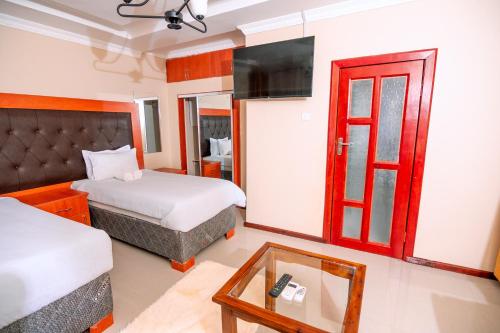 a hotel room with two beds and a red door at Luxe Countryside Convention Center in Livingstone